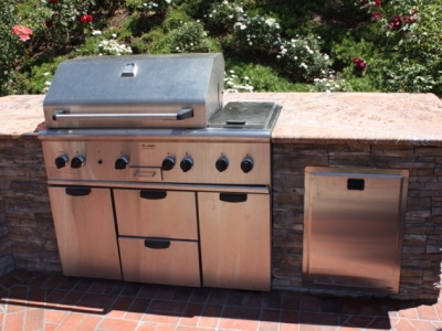 Elite outdoor grill setup with stone features and refrigerated storage